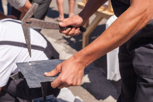 Exemple d'ardoisier façonnant des ardoises pour des travaux de toiture à Namur.